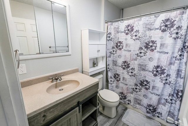 full bath featuring toilet, curtained shower, a textured ceiling, wood finished floors, and vanity