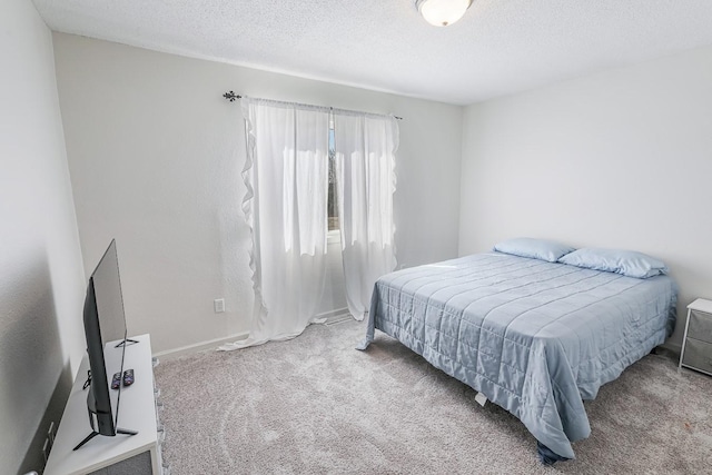 carpeted bedroom featuring a textured ceiling and baseboards