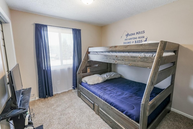 carpeted bedroom featuring baseboards and a textured ceiling