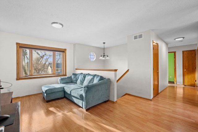 living room with visible vents, light wood-type flooring, and baseboards