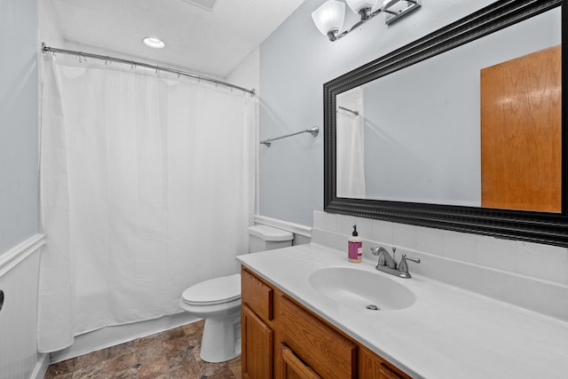 full bathroom with vanity, toilet, and stone finish flooring