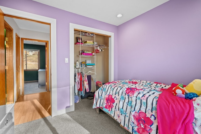 carpeted bedroom with a closet and baseboards