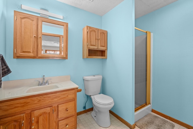 full bathroom featuring a shower stall, baseboards, toilet, vanity, and a textured ceiling