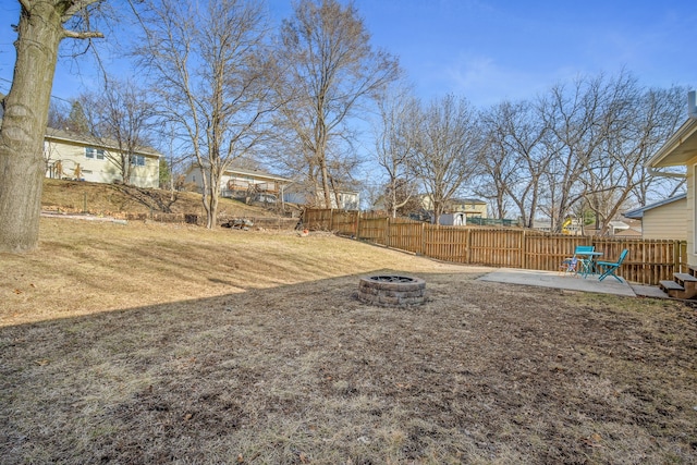 view of yard with a patio, fence, and an outdoor fire pit