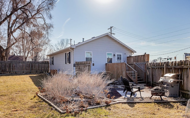 back of house with a patio area, a fire pit, a yard, and fence