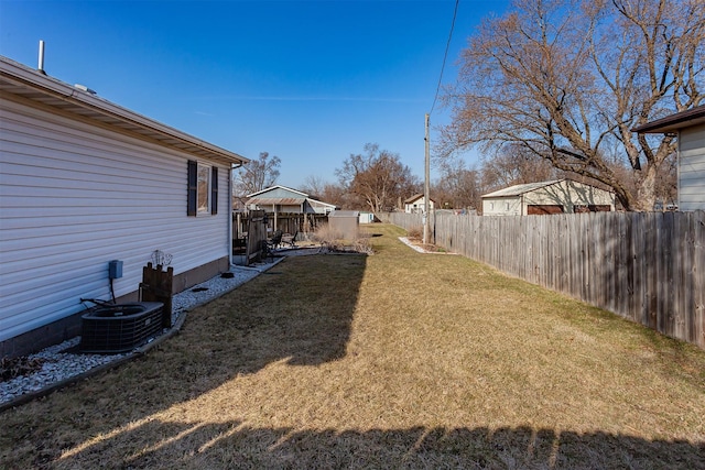 view of yard featuring a fenced backyard and central AC