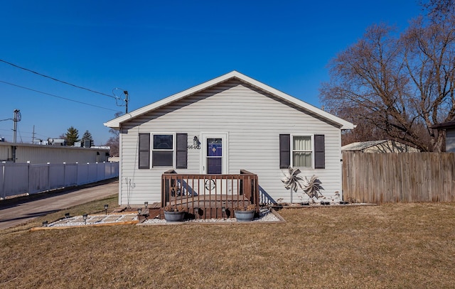 bungalow with a front lawn and fence