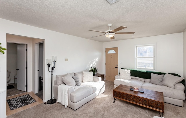 living area with wood finished floors, a ceiling fan, visible vents, and a textured ceiling