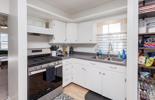 kitchen featuring a healthy amount of sunlight, white cabinetry, stainless steel gas range, and a sink