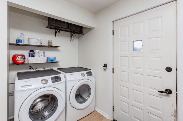 washroom with washer and dryer, laundry area, light wood-style flooring, and baseboards