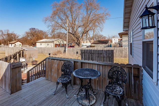 wooden deck with a residential view, an outbuilding, and a fenced backyard