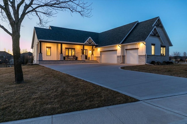 view of front facade featuring a lawn, board and batten siding, concrete driveway, and an attached garage