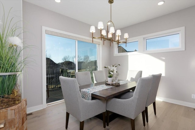 dining space with recessed lighting, baseboards, an inviting chandelier, and light wood finished floors