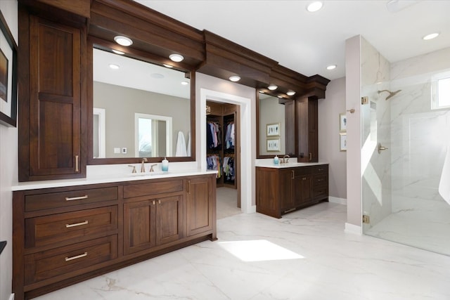 full bathroom featuring a marble finish shower, marble finish floor, two vanities, and a sink