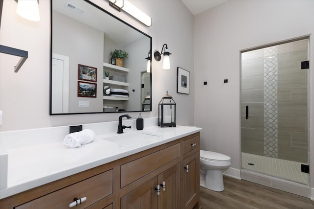 full bathroom featuring vanity, wood finished floors, visible vents, a shower stall, and toilet