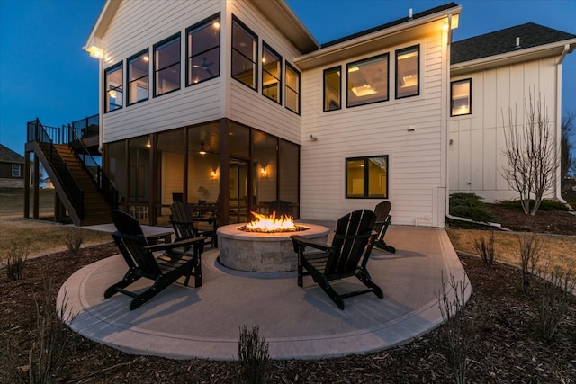 back of property featuring stairway, a sunroom, a fire pit, and a patio area