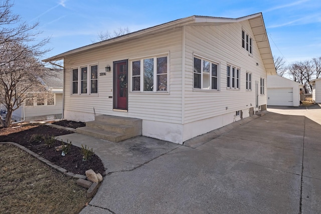 view of front facade featuring entry steps, an outbuilding, and a garage