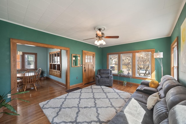 living area with ceiling fan, baseboards, and wood finished floors