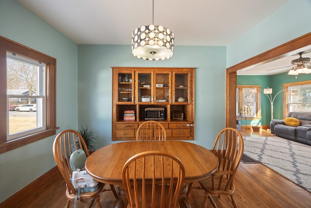 dining space with wood finished floors and a ceiling fan