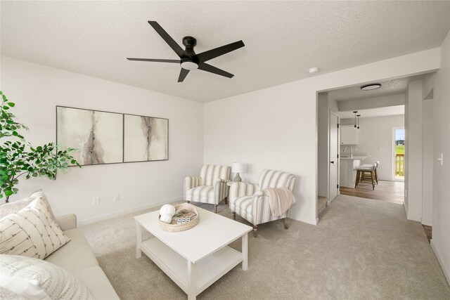 1506 E Girard Ave, Indianola, IA 50125 - living room with ceiling fan, light carpet, a textured ceiling, and baseboards