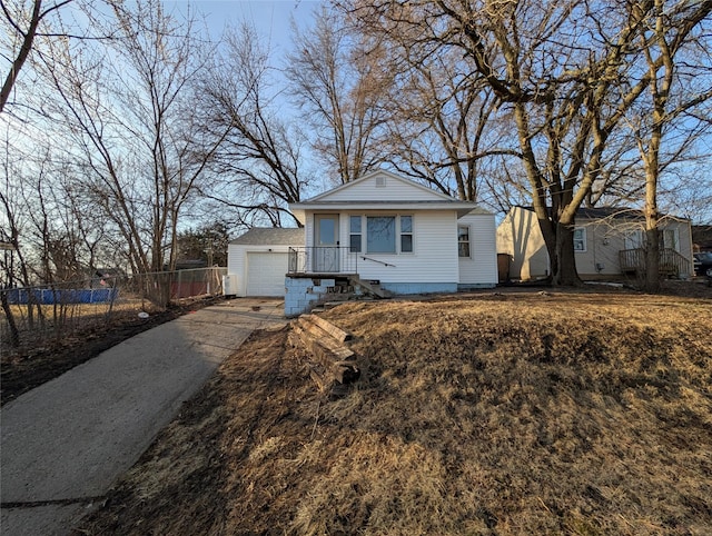 view of front of house featuring an outbuilding, fence, a garage, and driveway