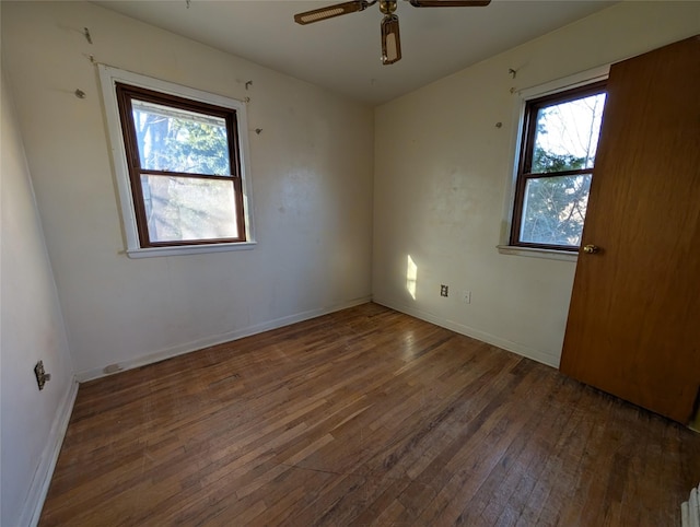 spare room with ceiling fan, baseboards, and wood-type flooring