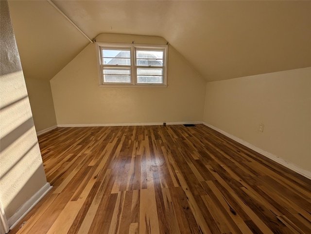 bonus room with vaulted ceiling, baseboards, and wood-type flooring