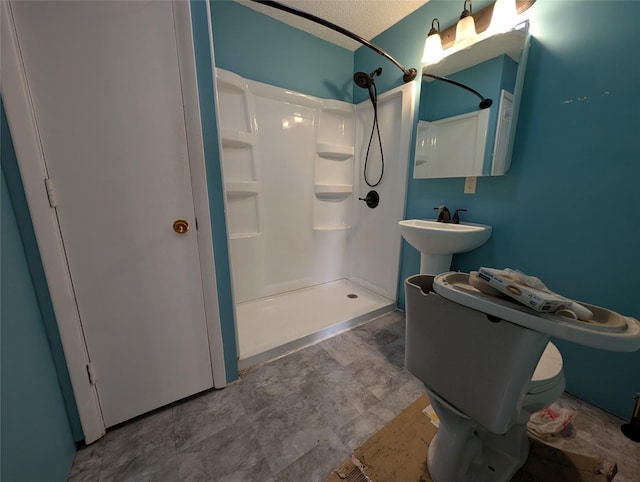 bathroom with a shower, a textured ceiling, and toilet