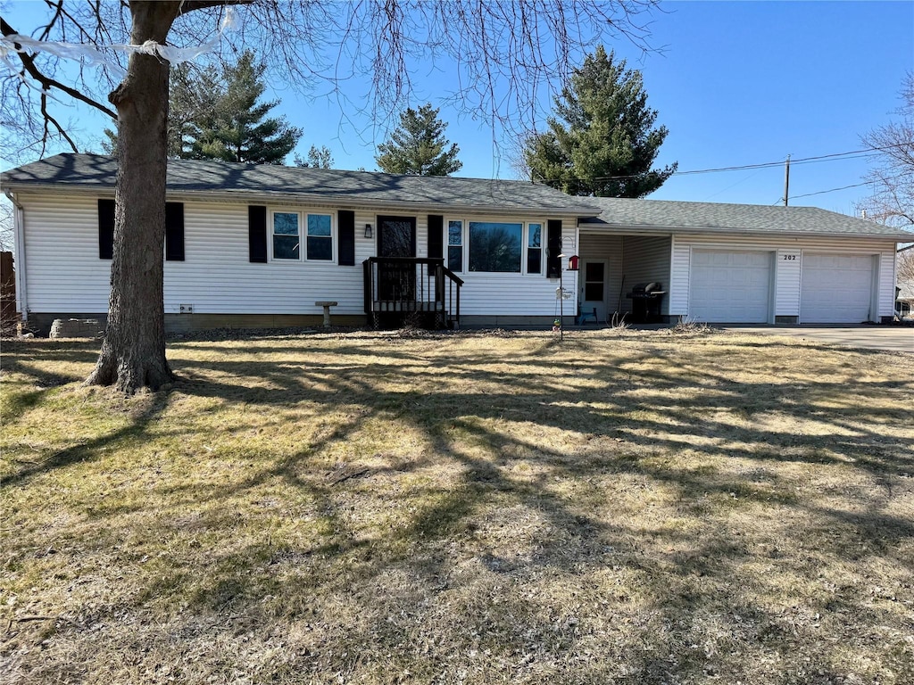 single story home with an attached garage, driveway, and a front lawn