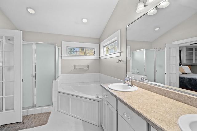 bathroom with ensuite bath, lofted ceiling, double vanity, a sink, and a shower stall