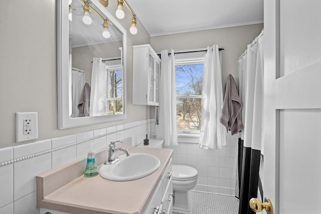 bathroom featuring tile patterned floors, tile walls, vanity, and ornamental molding