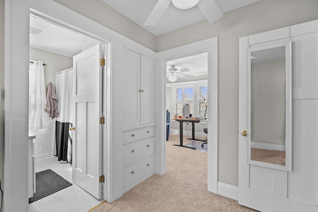 corridor with visible vents, light colored carpet, and baseboards