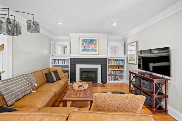 living area featuring ornamental molding, a fireplace, baseboards, and wood finished floors