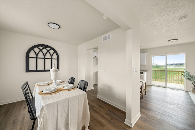 1502 E Girard Ave, Indianola, IA 50125 - dining area featuring baseboards, dark wood-type flooring, and a textured ceiling