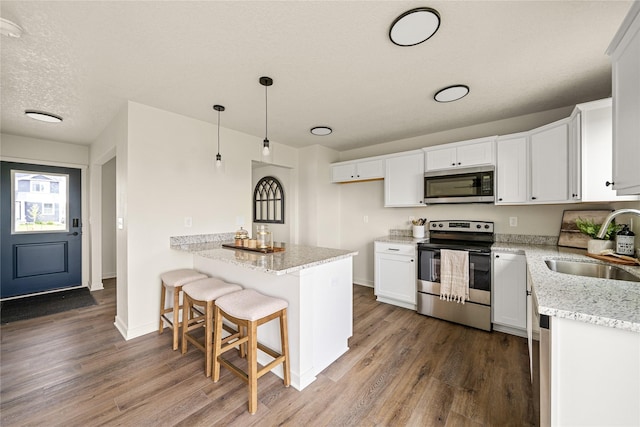 1502 E Girard Ave, Indianola, IA 50125 - kitchen with appliances with stainless steel finishes, a sink, dark wood-style flooring, and light stone counters