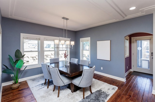 dining space featuring dark wood-type flooring, recessed lighting, baseboards, and arched walkways