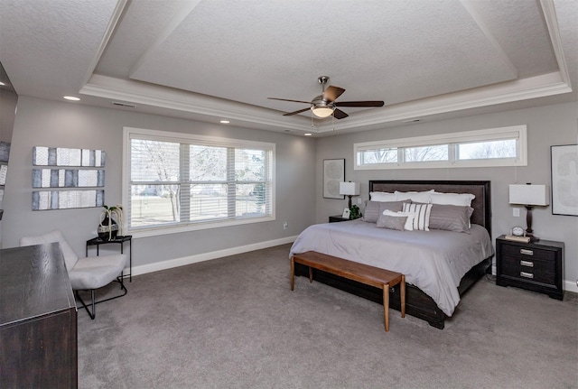 carpeted bedroom featuring visible vents, a textured ceiling, baseboards, and a tray ceiling