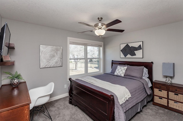 carpeted bedroom featuring baseboards, a textured ceiling, and ceiling fan