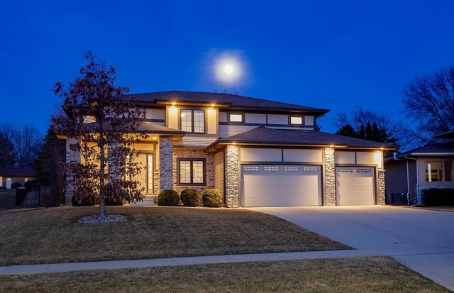 prairie-style home with stone siding, an attached garage, a lawn, stucco siding, and driveway