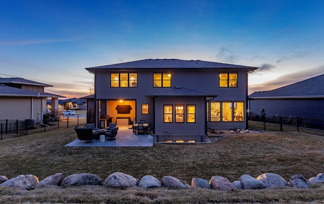 rear view of house with a patio, a fenced backyard, a lawn, and central AC