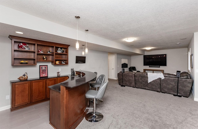 bar featuring indoor wet bar, baseboards, a textured ceiling, and pendant lighting