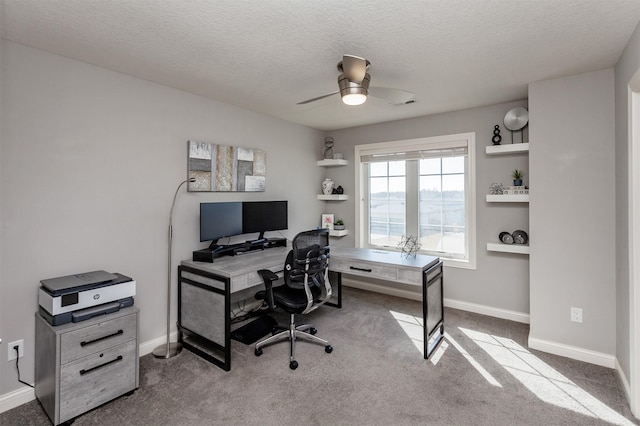 office space with a ceiling fan, carpet, baseboards, and a textured ceiling