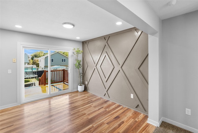 empty room with recessed lighting, light wood-style flooring, and baseboards