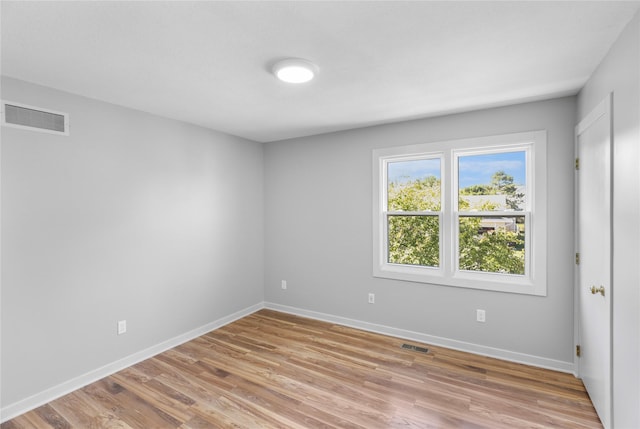 empty room with light wood-style flooring, baseboards, and visible vents