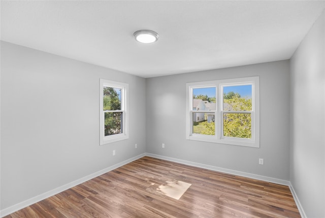 unfurnished room featuring baseboards and wood finished floors