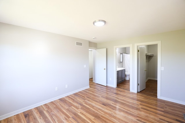 unfurnished bedroom featuring light wood-style flooring, baseboards, and visible vents