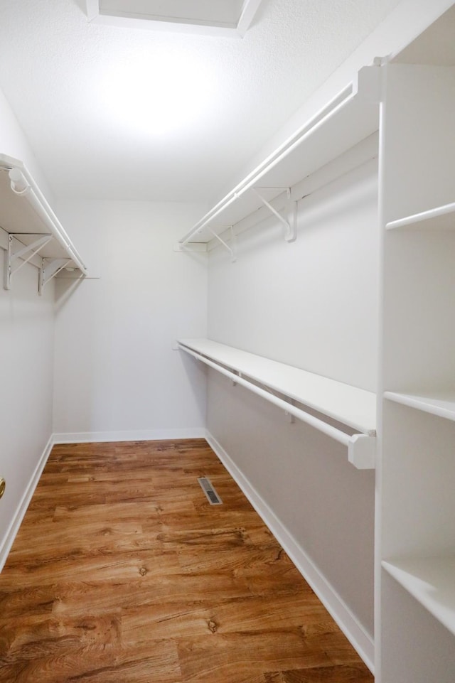 walk in closet featuring visible vents and wood finished floors