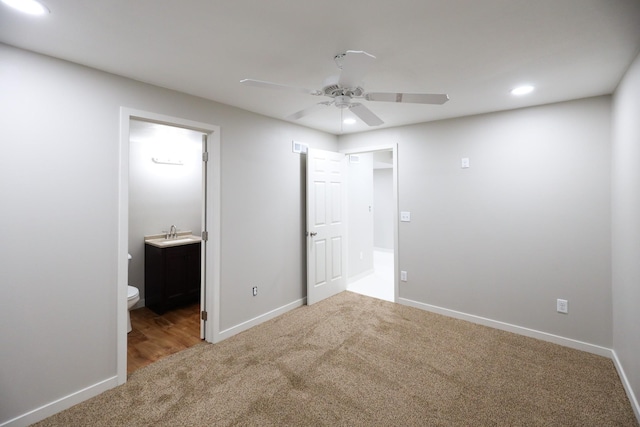 unfurnished bedroom featuring carpet flooring, recessed lighting, baseboards, and a sink