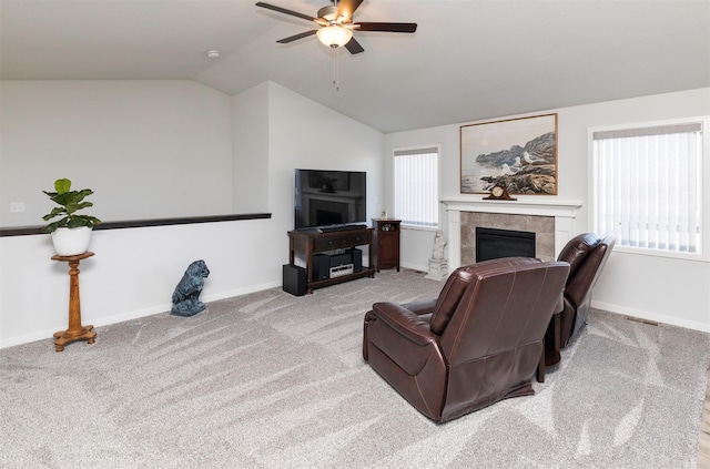 living room featuring lofted ceiling, a fireplace, carpet floors, and a healthy amount of sunlight