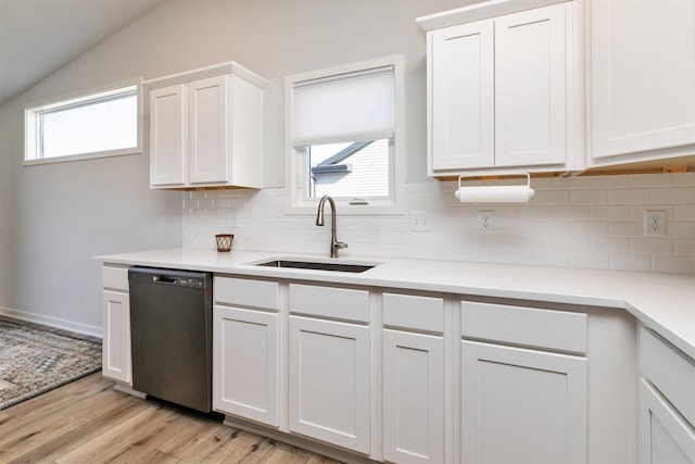 kitchen featuring dishwasher, light wood-type flooring, light countertops, white cabinetry, and a sink